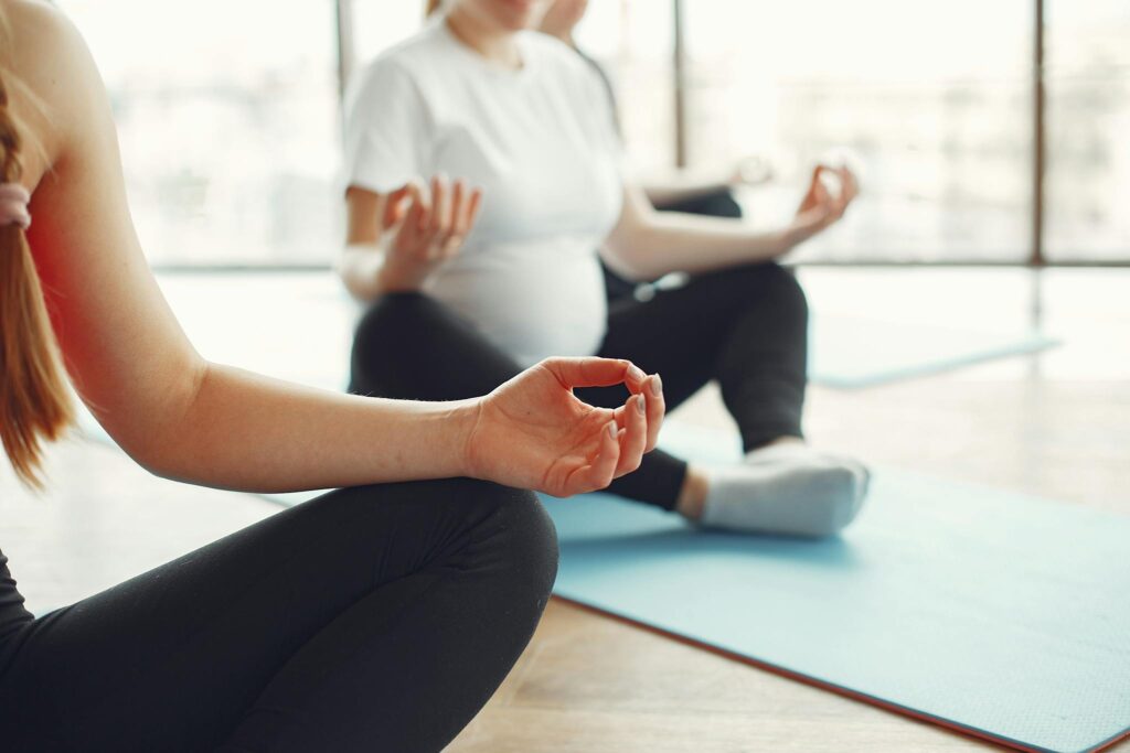 Pregnant women meditating in fitness studio